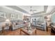 Spacious living room with comfortable seating, wood floors, ceiling fan, and view into the dining area at 626 Magellan Dr, Sarasota, FL 34243