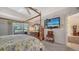 Comfortable bedroom with four-poster bed, ceiling fan, carpet floors, and a view of the lanai at 626 Magellan Dr, Sarasota, FL 34243
