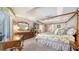 Spacious main bedroom features a four-poster bed, dresser, desk, and access to outdoor patio at 626 Magellan Dr, Sarasota, FL 34243