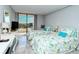 Sunlit bedroom with dual beds and sliding door access to a balcony with neighborhood views at 6415 Midnight Pass Rd # 607, Sarasota, FL 34242