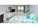 Sunlit bedroom with dual beds and sliding door access to a balcony with neighborhood views at 6415 Midnight Pass Rd # 607, Sarasota, FL 34242