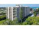 Exterior of the modern condo building showing multiple floors, balconies, and nearby greenery at 6415 Midnight Pass Rd # 607, Sarasota, FL 34242