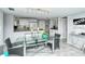 Open dining area featuring a glass table, wicker chairs, and views of the kitchen at 6415 Midnight Pass Rd # 607, Sarasota, FL 34242