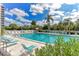 Community pool surrounded by lush greenery, lounge chairs, and shade in this luxury condo community at 6415 Midnight Pass Rd # 607, Sarasota, FL 34242