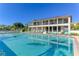 Community pool and sundeck with lounge chairs, umbrellas and bright blue skies in this luxury condo community at 6415 Midnight Pass Rd # 607, Sarasota, FL 34242