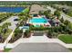 Aerial view of a community pool area, showcasing a pool, a lake, palm trees, and the neighborhood at 6492 Positano Ct, Sarasota, FL 34243
