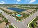 Beautiful aerial view of the community featuring a lake, swimming pool, and lush landscaping at 6492 Positano Ct, Sarasota, FL 34243