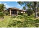 Backyard featuring a lush lawn, mature trees, and a screened lanai at 6492 Positano Ct, Sarasota, FL 34243