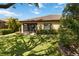 Manicured backyard featuring lush green grass, mature trees, and a screened-in lanai at 6492 Positano Ct, Sarasota, FL 34243