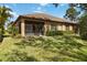 Beautiful backyard featuring a lawn, a screened-in lanai, trimmed hedges, and a tiled roof at 6492 Positano Ct, Sarasota, FL 34243