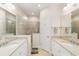 Luxurious bathroom with dual sinks, a glass-enclosed shower, and neutral tile, provides a spa-like retreat at 6492 Positano Ct, Sarasota, FL 34243