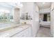 Bright bathroom with dual vanities and a view into the bedroom, creating a seamless and luxurious experience at 6492 Positano Ct, Sarasota, FL 34243