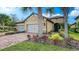 Charming single-story home with a well-manicured lawn, brick driveway, and beautiful landscaping at 6492 Positano Ct, Sarasota, FL 34243