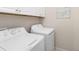 Bright laundry room featuring a white washer and dryer set with white cabinets above at 6492 Positano Ct, Sarasota, FL 34243
