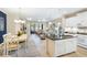 Bright, open-concept living space with dining area, kitchen island, and sliding glass doors to a screened porch at 6492 Positano Ct, Sarasota, FL 34243