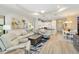 Open living space features light wood floors, tray ceilings, a white sofa, and a view into the kitchen at 6492 Positano Ct, Sarasota, FL 34243