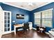 The office is painted in a gorgeous blue, and features a glass door and laminate flooring at 6492 Positano Ct, Sarasota, FL 34243