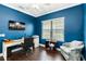 Well-lit office with blue walls, wood flooring, and two windows that provide plenty of natural light at 6492 Positano Ct, Sarasota, FL 34243