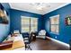 Cozy office with blue walls, wood flooring, a ceiling fan, and two windows for ample natural light at 6492 Positano Ct, Sarasota, FL 34243