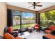 Enclosed sunroom with wicker furniture, tiled floors, a ceiling fan, and large windows overlooking the backyard at 6492 Positano Ct, Sarasota, FL 34243