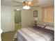 Bedroom with a ceiling fan, adjacent bathroom, and ample natural light at 705 Blackburn Blvd, North Port, FL 34287