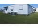 Home exterior showcasing a well-maintained lawn and modern air conditioning unit at 705 Blackburn Blvd, North Port, FL 34287