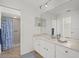 Bright bathroom with a shower featuring a blue patterned curtain, and a large vanity with a marble countertop at 7205 Wood Creek Dr # 16, Sarasota, FL 34231