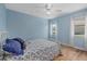 Cozy bedroom with blue walls, a ceiling fan, hardwood floors, and natural light from the windows at 7205 Wood Creek Dr # 16, Sarasota, FL 34231