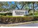 An exterior view of the Woodside Terrace community sign surrounded by mature landscaping at 7205 Wood Creek Dr # 16, Sarasota, FL 34231