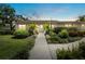 Charming single story home with a landscaped yard and walkway to the front door at dusk at 7205 Wood Creek Dr # 16, Sarasota, FL 34231