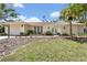 Charming home featuring a lush lawn, tropical landscaping, arched door frame and a two car garage at 7542 Swanson Ln, Sarasota, FL 34231