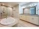 Bright bathroom featuring a soaking tub, granite counters, a walk-in shower, and modern fixtures at 7810 34Th W Ave # 103, Bradenton, FL 34209