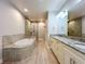 Spacious bathroom featuring wood tile floors, soaking tub, and double sink vanity with granite countertops at 7810 34Th W Ave # 103, Bradenton, FL 34209
