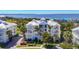 Luxury condominium building features stunning waterfront views, a white metal roof, and lush landscaping at 7810 34Th W Ave # 103, Bradenton, FL 34209