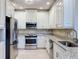 Modern kitchen featuring stainless steel appliances, granite countertops and bright white cabinetry at 7810 34Th W Ave # 103, Bradenton, FL 34209