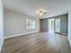 Open living room with light wood floors, windows with plantation shutters and access to outdoor patio at 7810 34Th W Ave # 103, Bradenton, FL 34209