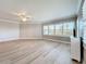 Spacious living room featuring light wood floors, ceiling fan, and multiple windows with plantation shutters at 7810 34Th W Ave # 103, Bradenton, FL 34209