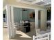 View of the community outdoor kitchen and bar area with white dining sets and a barbecue grill at 7810 34Th W Ave # 103, Bradenton, FL 34209