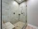 Modern bathroom shower featuring neutral tiling, a built-in bench, and a glass door at 7810 34Th W Ave # 103, Bradenton, FL 34209