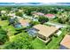 Birds-eye view of a home nestled among green trees, boasting a backyard pool, and manicured lawn at 8449 Lone Eagle Way, Sarasota, FL 34241