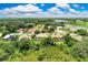 Aerial view of a home with mature trees, a large lawn, and a screened-in pool at 8449 Lone Eagle Way, Sarasota, FL 34241