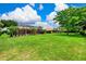 Sprawling backyard featuring lush landscaping, large lawn, and screened-in pool area at 8449 Lone Eagle Way, Sarasota, FL 34241