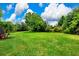 Very Large backyard featuring lush green lawn, mature trees, and a screened in lanai at 8449 Lone Eagle Way, Sarasota, FL 34241