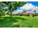 Large backyard featuring lush green lawn, mature trees, and a screened in lanai at 8449 Lone Eagle Way, Sarasota, FL 34241
