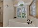 Elegant bathroom featuring a soaking tub with black hardware, a walk-in shower, and plantation shutters at 8449 Lone Eagle Way, Sarasota, FL 34241