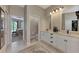 Bathroom featuring dual sinks, white cabinetry, and views of the Primary bedroom and closet at 8449 Lone Eagle Way, Sarasota, FL 34241