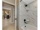 Modern bathroom featuring a tub and shower with marble tile and black hardware at 8449 Lone Eagle Way, Sarasota, FL 34241