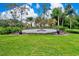 Stone entrance to Misty Creek community featuring mature landscaping and blue decorative urns at 8449 Lone Eagle Way, Sarasota, FL 34241