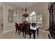 Elegant dining room with a dark wood table set beneath an ornate chandelier and sunlit window at 8449 Lone Eagle Way, Sarasota, FL 34241