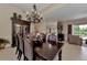 A dining room with dark wood furniture, a chandelier, and seamless flow into the living area at 8449 Lone Eagle Way, Sarasota, FL 34241